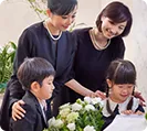 家族葬2日のサムネイル画像 女性2人と子供2人が棺前に集まっている
