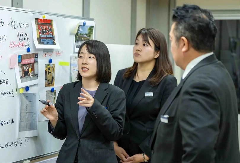 施工の前に社内でミーティングをする3人のスタッフの写真