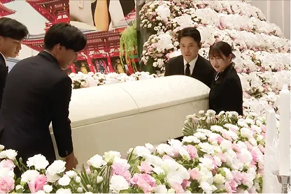 たくさんの花に囲まれた棺を持つご親族