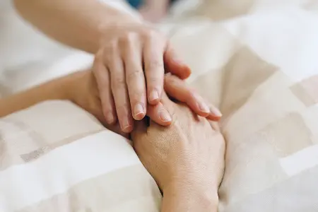 故人様の手に手を添える納棺師の写真