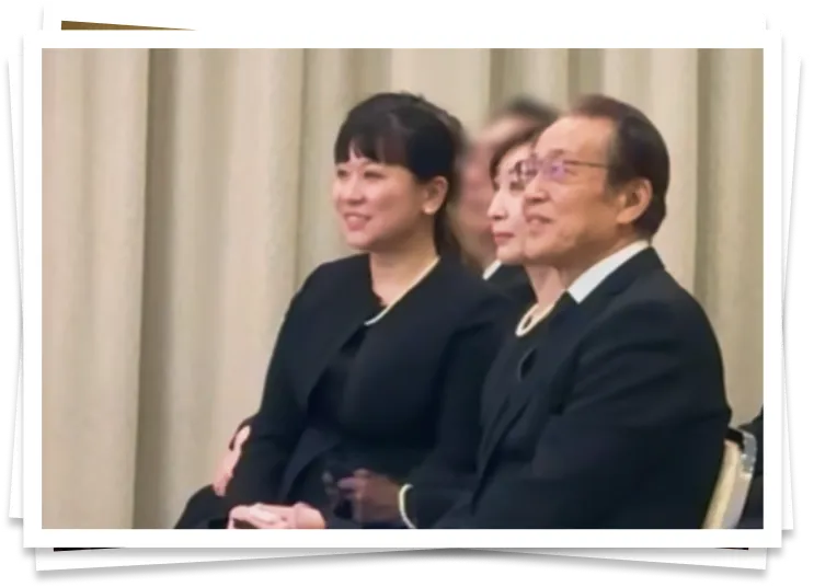 参列者と共に映像を見て微笑むご家族