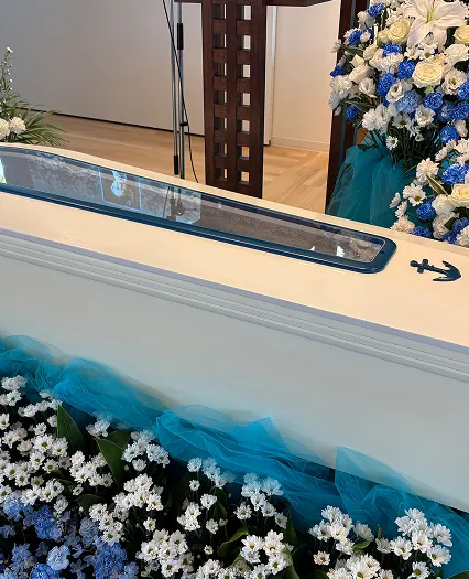 葬儀事例のサムネイル画像 海のようなブルーの空間に置かれたクルーザーをイメージさせるお棺