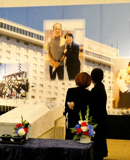 葬儀事例のサムネイル画像 新座市営墓園斎場にてホテルの画像を組み込んだ祭壇を眺める奥様