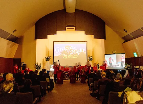 葬儀事例「夫は最高のバンドリーダー」のギャラリー画像2枚目 大型スクリーンの下ジャズバンド仲間とお見送り