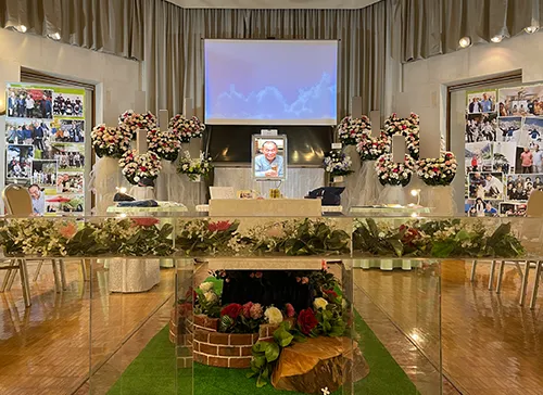 葬儀事例「乾杯！仲間の笑顔でお見送り」のギャラリー画像3枚目 祭壇の左右にはお写真を多数配置し中央には映像用の大型スクリーン