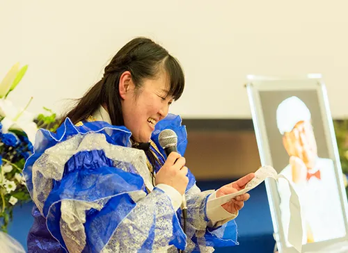 葬儀事例「夫は最高のバンドリーダー」のギャラリー画像4枚目 ご主人のお葬式でMCをされる奥様