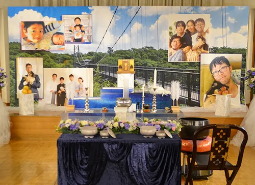 葬儀事例「生き抜いた、自慢の息子」のギャラリー画像2枚目 思い出の場所を背景に家族のお写真がレイアウトされた祭壇