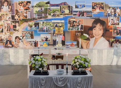 葬儀事例「妻とのリング交換」のギャラリー画像2枚目 思い出の地ハワイを背景に奥様と写真が並ぶ祭壇