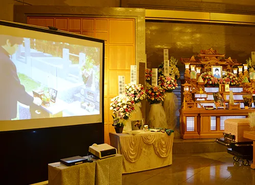 葬儀事例「おばあちゃんへの恩返し」のギャラリー画像4枚目 スクリーンにはありし日の故人様のお姿が