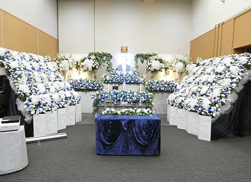 葬儀事例「父から学んだこと」のギャラリー画像4枚目 白とブルーのお花に囲まれた祭壇