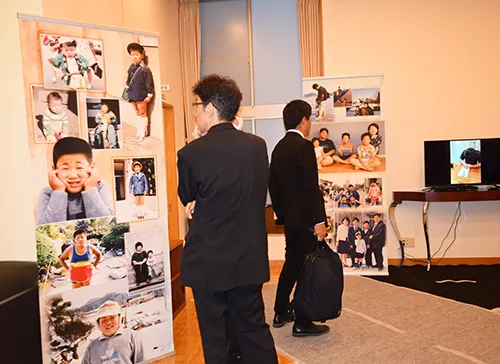 葬儀事例「トラック運転手のパパ」のギャラリー画像2枚目 思い出パネルを見られる参列者