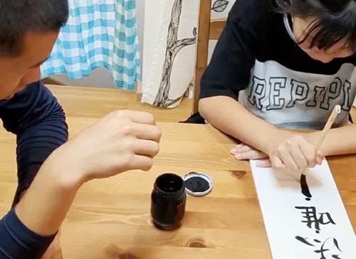 葬儀事例「トラック運転手のパパ」のギャラリー画像4枚目 供花の札を準備するご家族