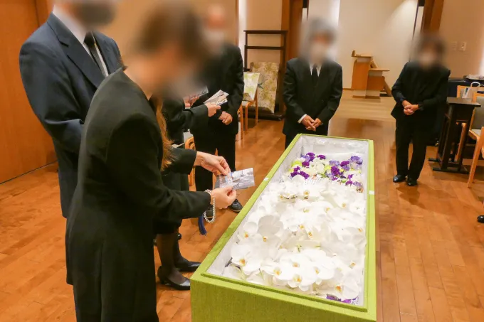 棺に写真入れる娘さん
