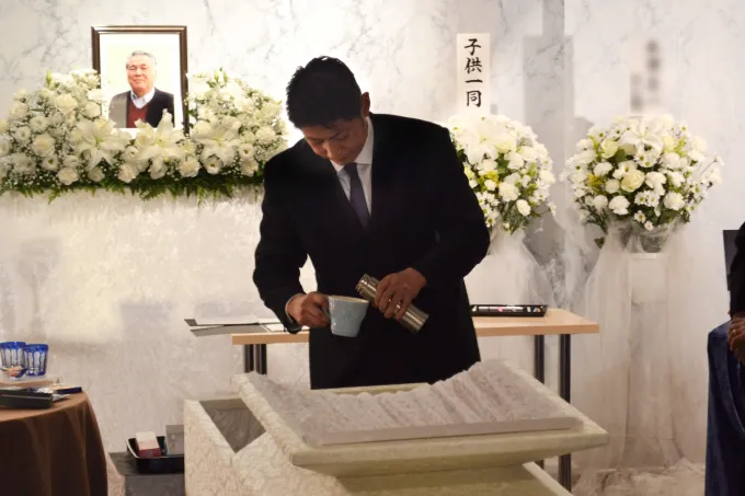 お父さんに選んだお酒を注ぐお子さん
