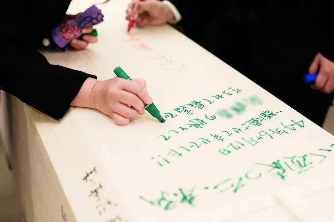 棺にメッセージを書く様子